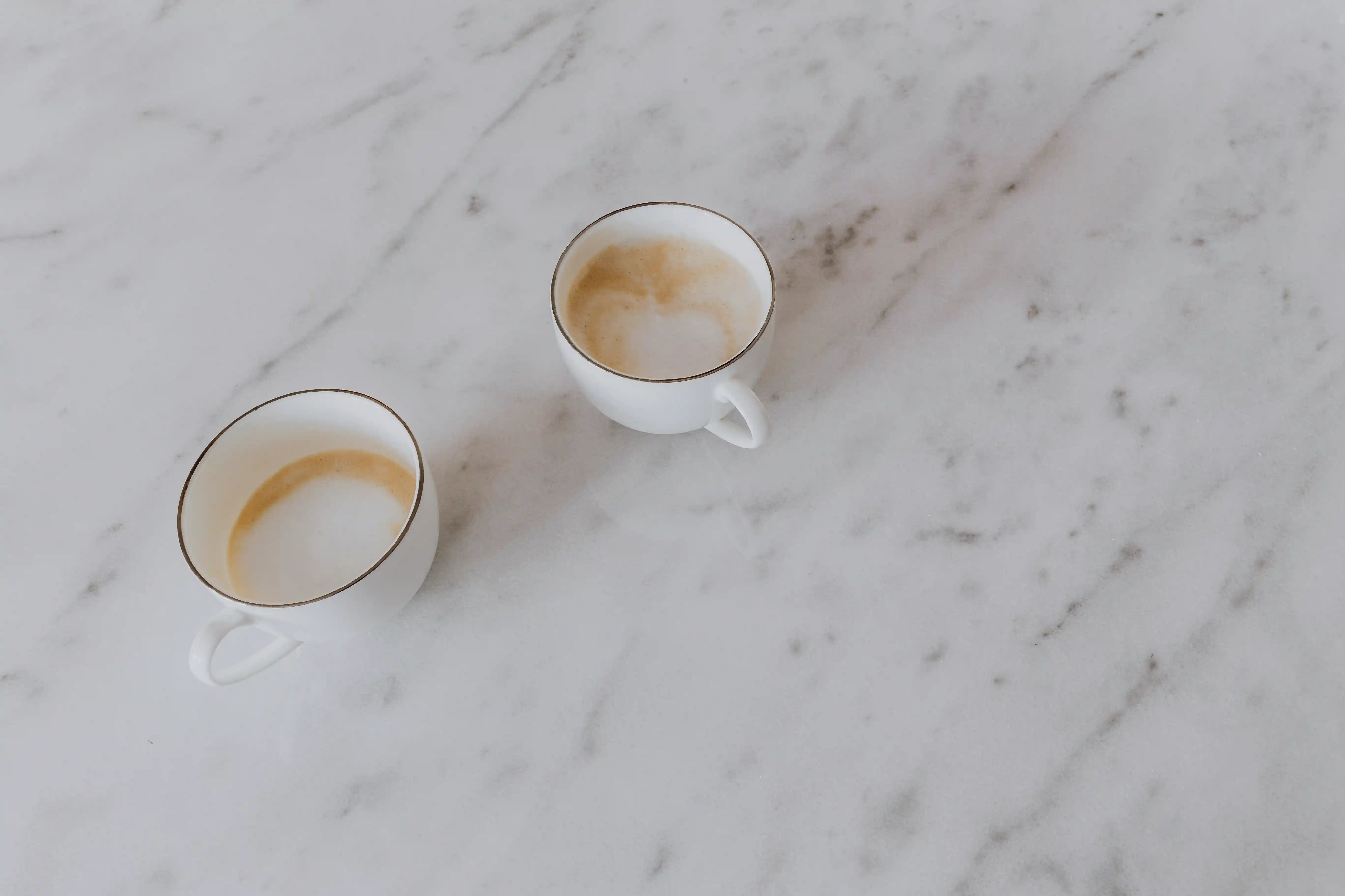 Two mugs with coffee on table